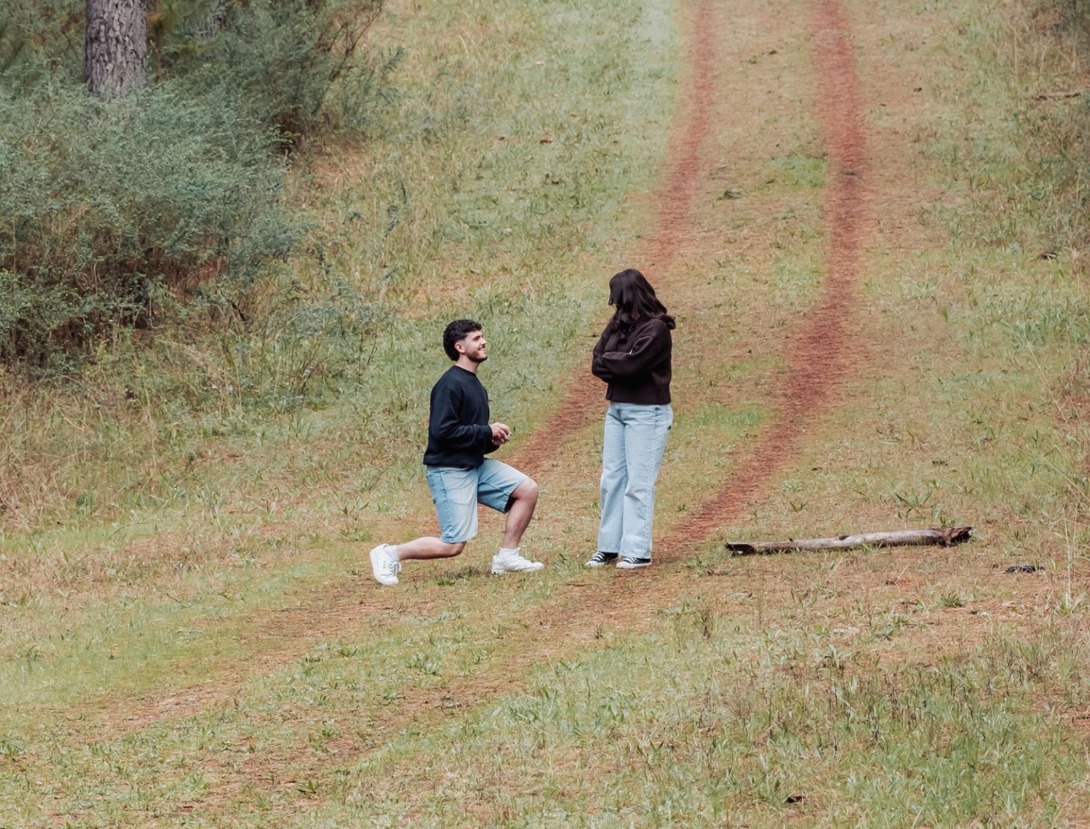 cabn at kuitpo forest proposal - tamsyn & blake 6 Man proposing on a grassy path, surrounded by nature, during a serene outdoor moment.