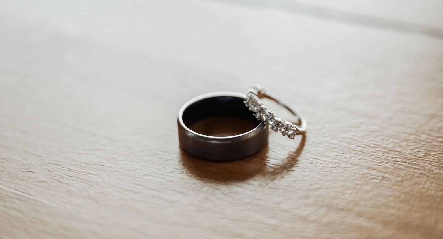 the lane vineyard wedding - caitlyn & craig 65 Elegant rings on wood surface illuminated by soft natural light.