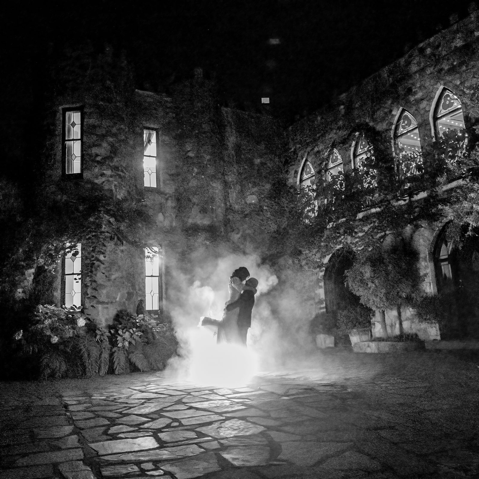 adelaide hills wedding at the manor - jo & dan 76 Romantic castle courtyard wedding kiss at night with dramatic smoke and glowing windows.
