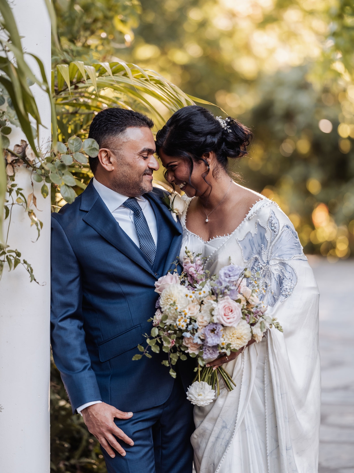 manor wedding in basket range - methmini & aravinda 151 Wedding couple in elegant attire sharing an intimate moment in a garden setting.