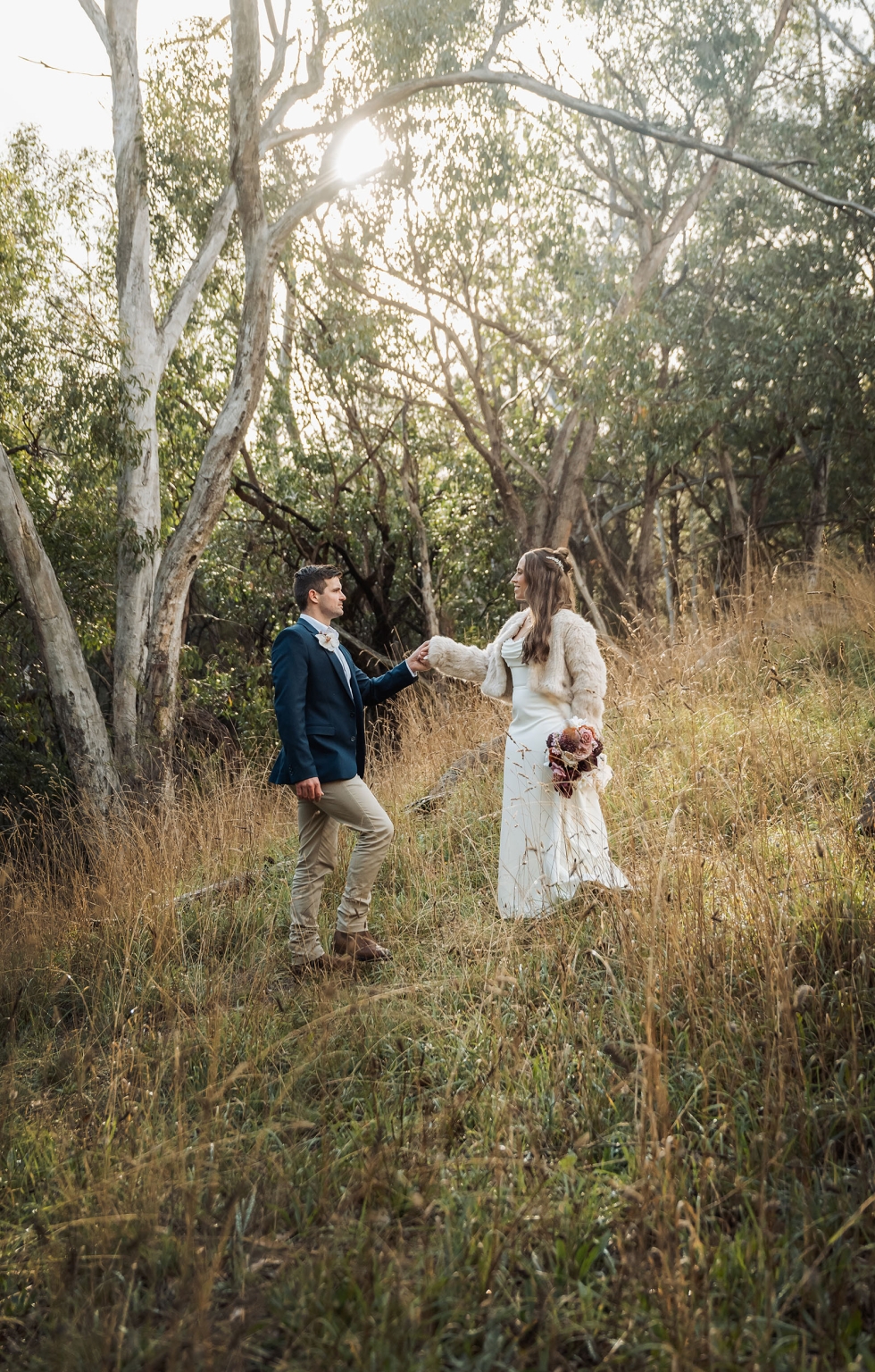 the lane vineyard wedding - caitlyn & craig 114 Elegant couple in a romantic, sunlit forest setting during a formal occasion.
