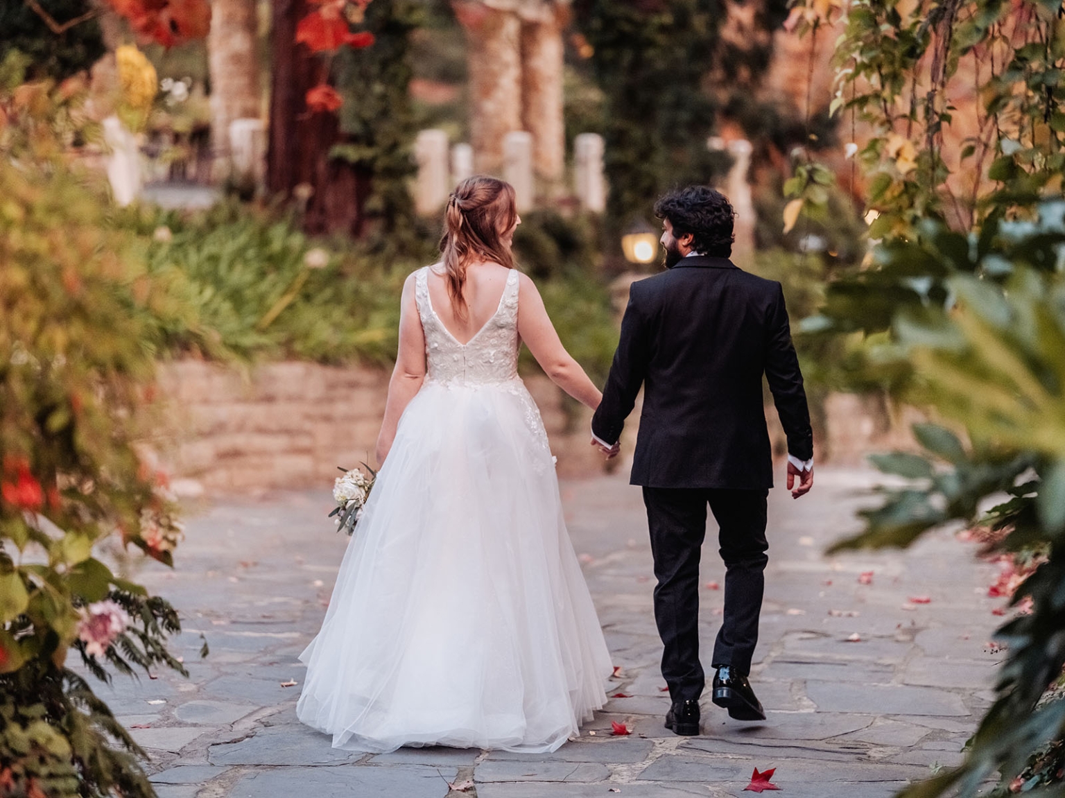 beautiful manor basket range wedding - sophie & theodore 131 Wedding couple walking on scenic garden path with autumn trees and romantic atmosphere.