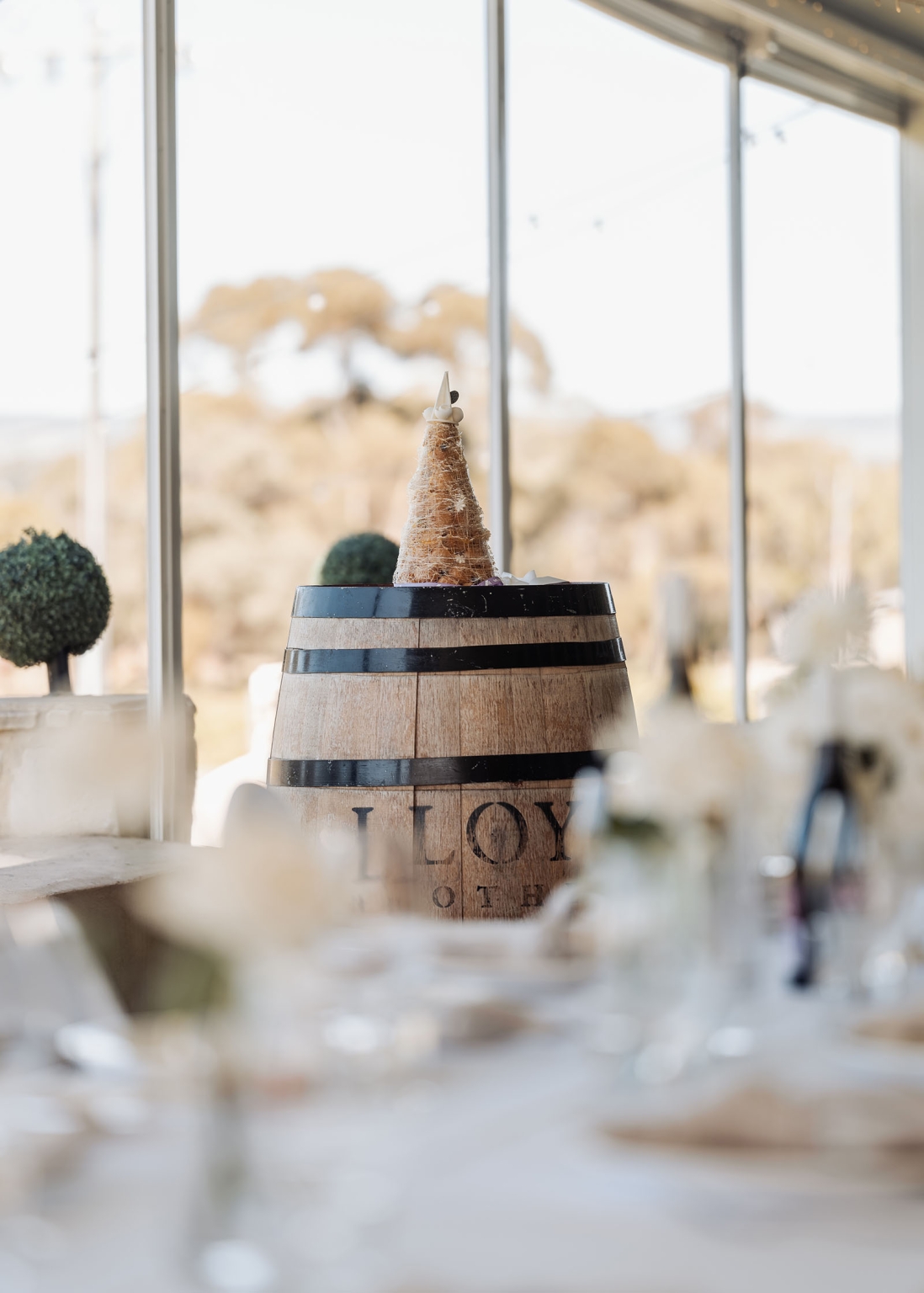 lloyd brothers wedding - dajana & tom 23 Elegant rustic setting with wooden barrel centerpiece and festive croquembouche dessert display.