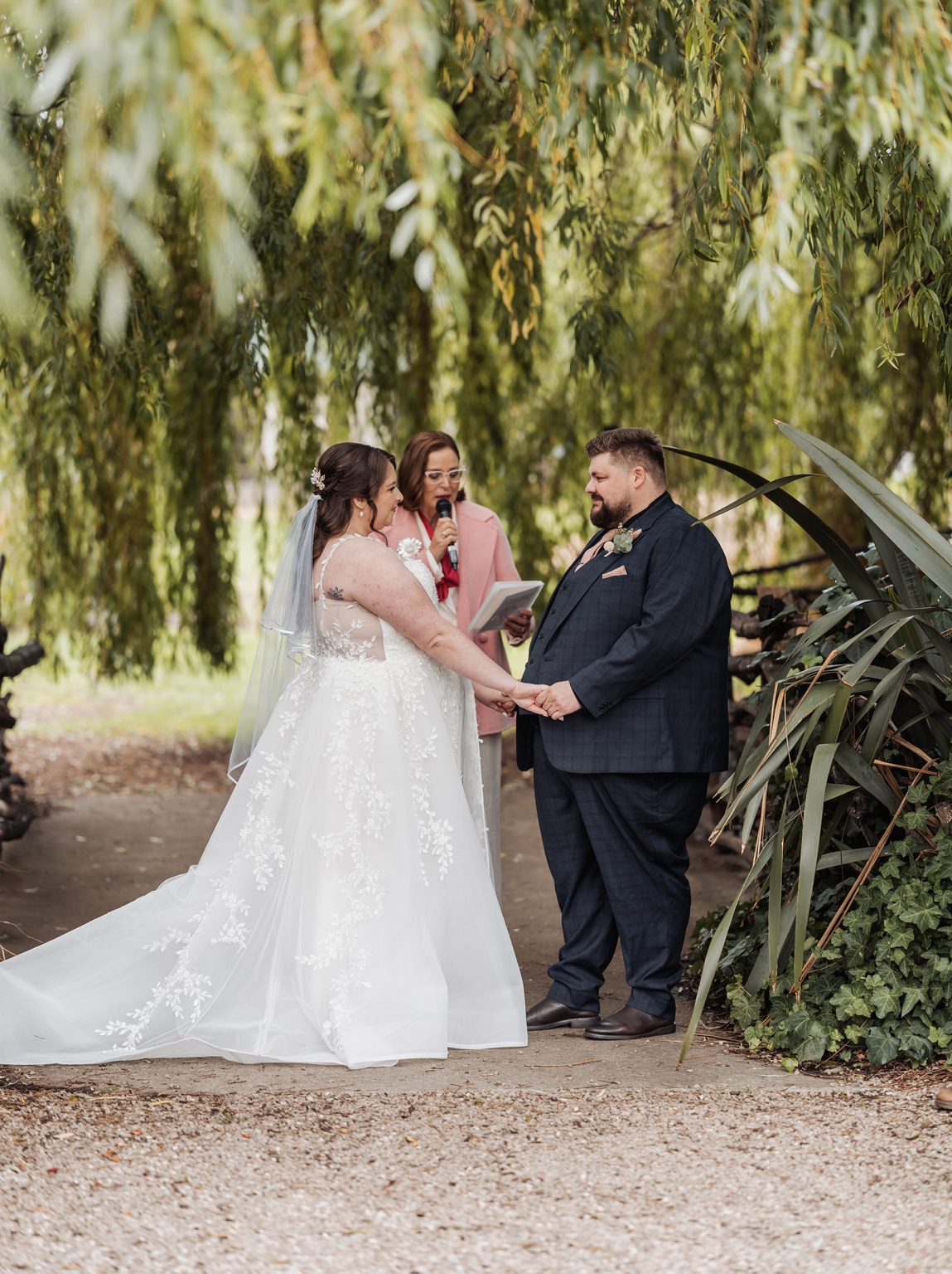 comida wedding - georgia & james 16 Outdoor wedding under willow canopy with bride, groom, and officiant exchanging vows.