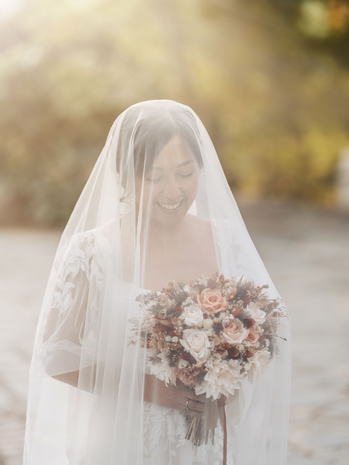 adelaide hills wedding at the manor - jo & dan 45 Veiled bride holding rustic wedding bouquet in romantic outdoor portrait.