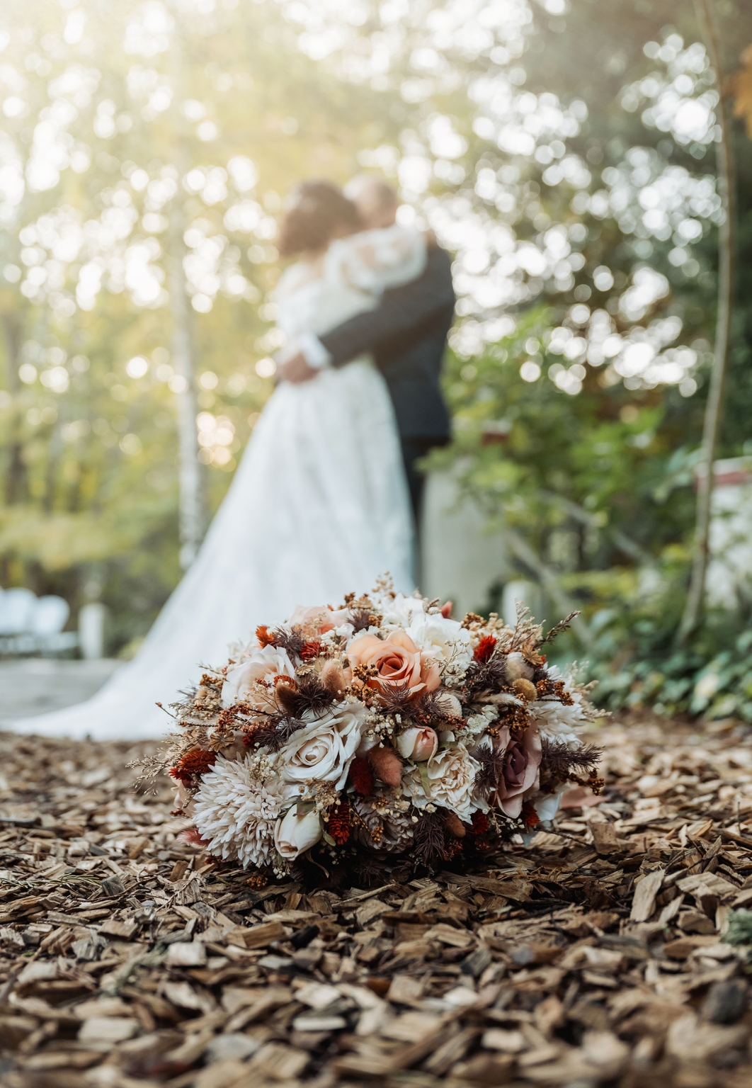 adelaide hills wedding at the manor - jo & dan 36 Rustic bridal bouquet in garden with blurred wedding couple kissing.