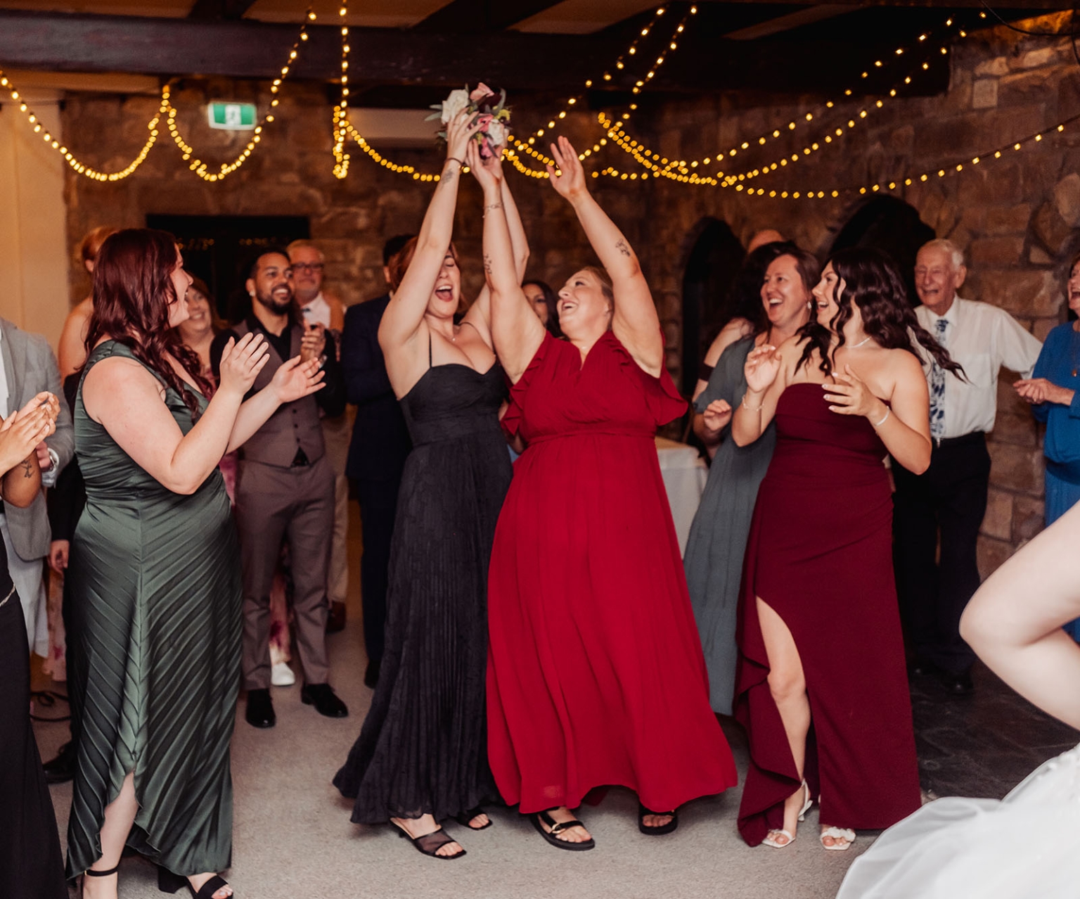 beautiful manor basket range wedding - sophie & theodore 150 Joyful wedding bouquet toss at a rustic reception with laughing guests.