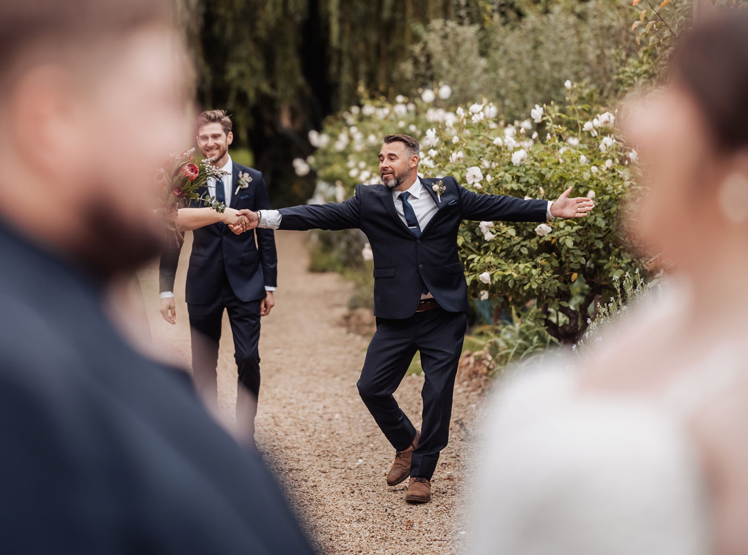 comida wedding - georgia & james 39 Joyful wedding celebration in lush garden with smiling guests and colorful flowers.
