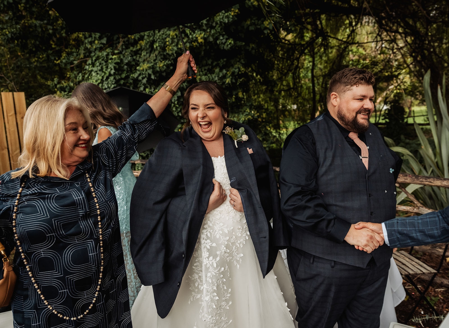 comida wedding - georgia & james 25 Bride laughing in lace gown with family at outdoor wedding celebration.