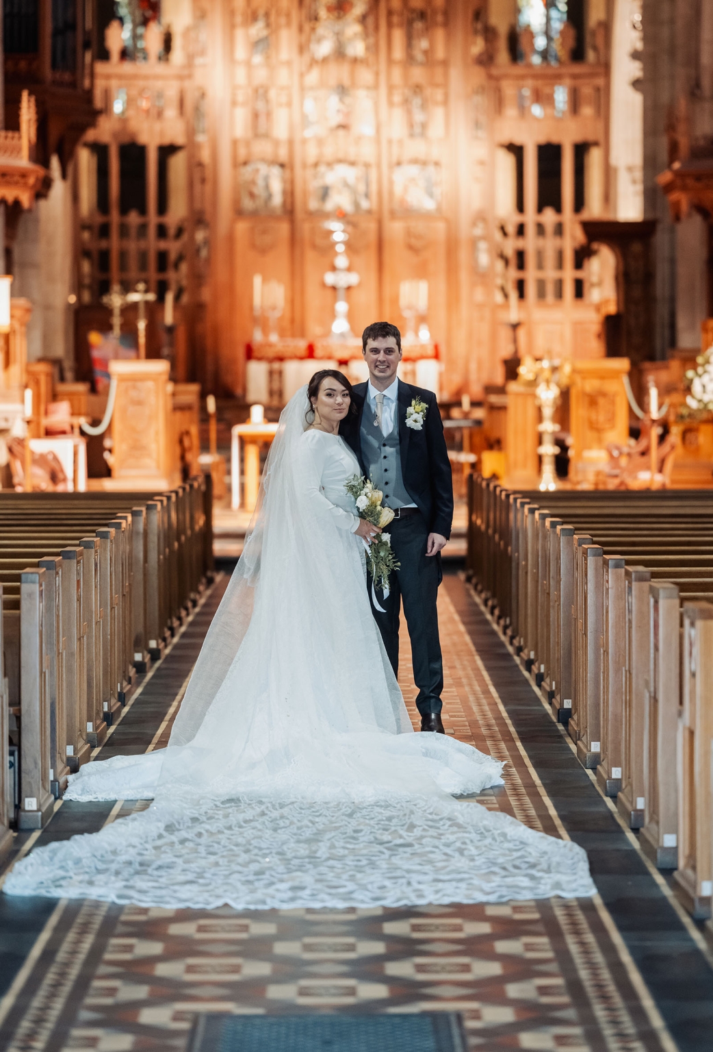 adelaide's st peter's cathedral wedding - irish & nick 37 Bride and groom wedding portrait in church aisle with lace train.