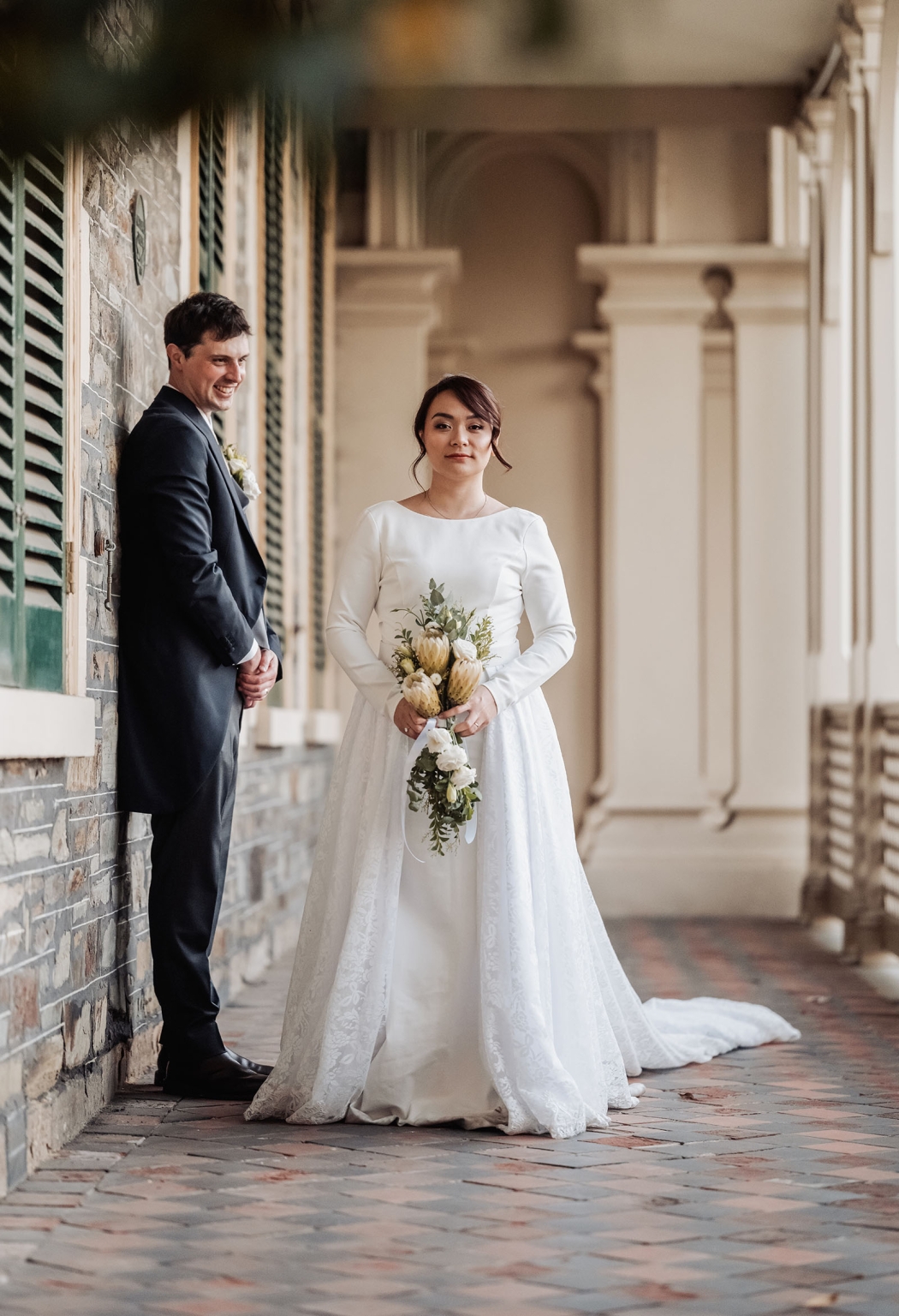 adelaide's st peter's cathedral wedding - irish & nick 45 Romantic bride and groom wedding portrait in a historic brick corridor.