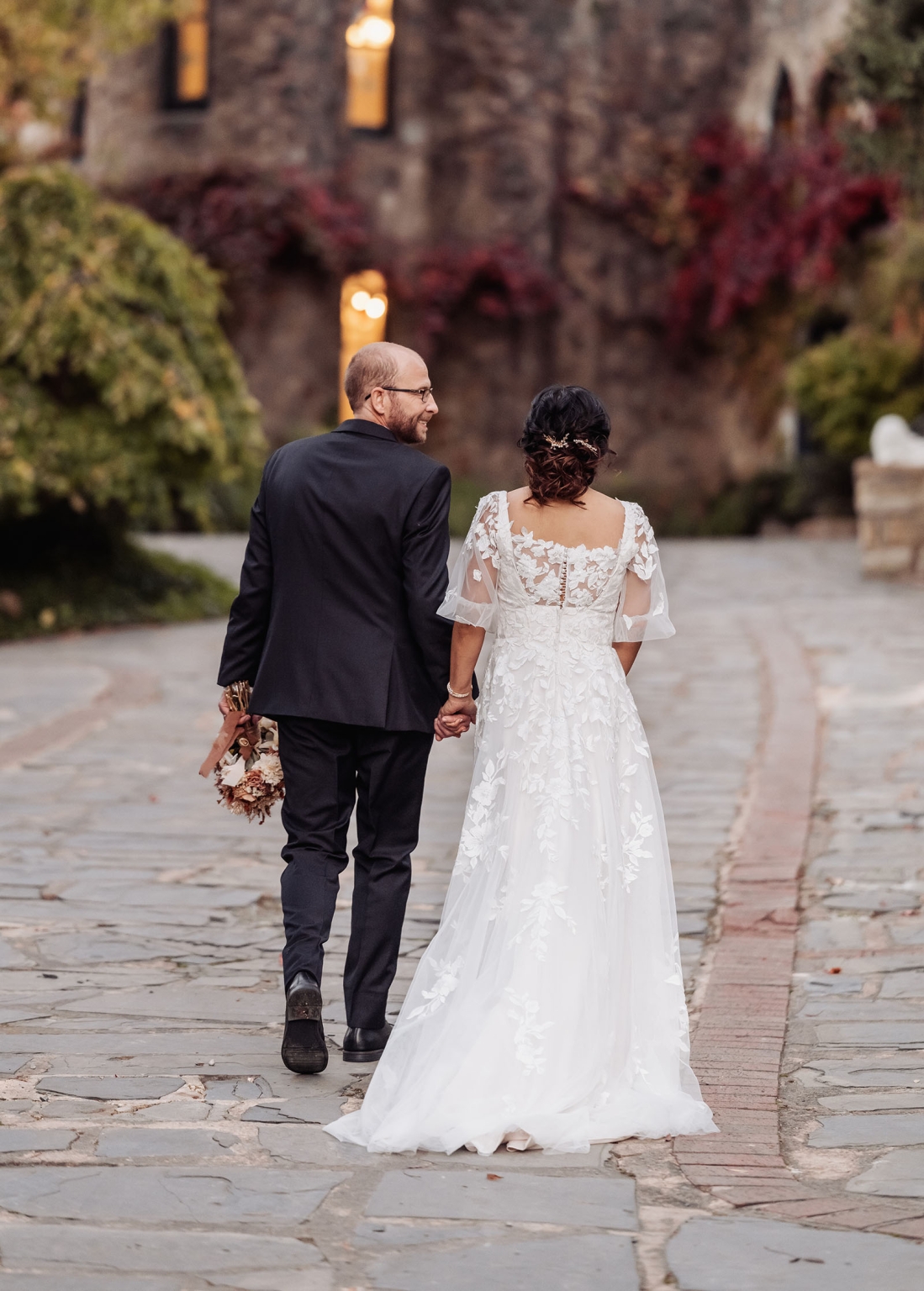 adelaide hills wedding at the manor - jo & dan 56 Bride and groom walking hand in hand on a romantic stone wedding path.