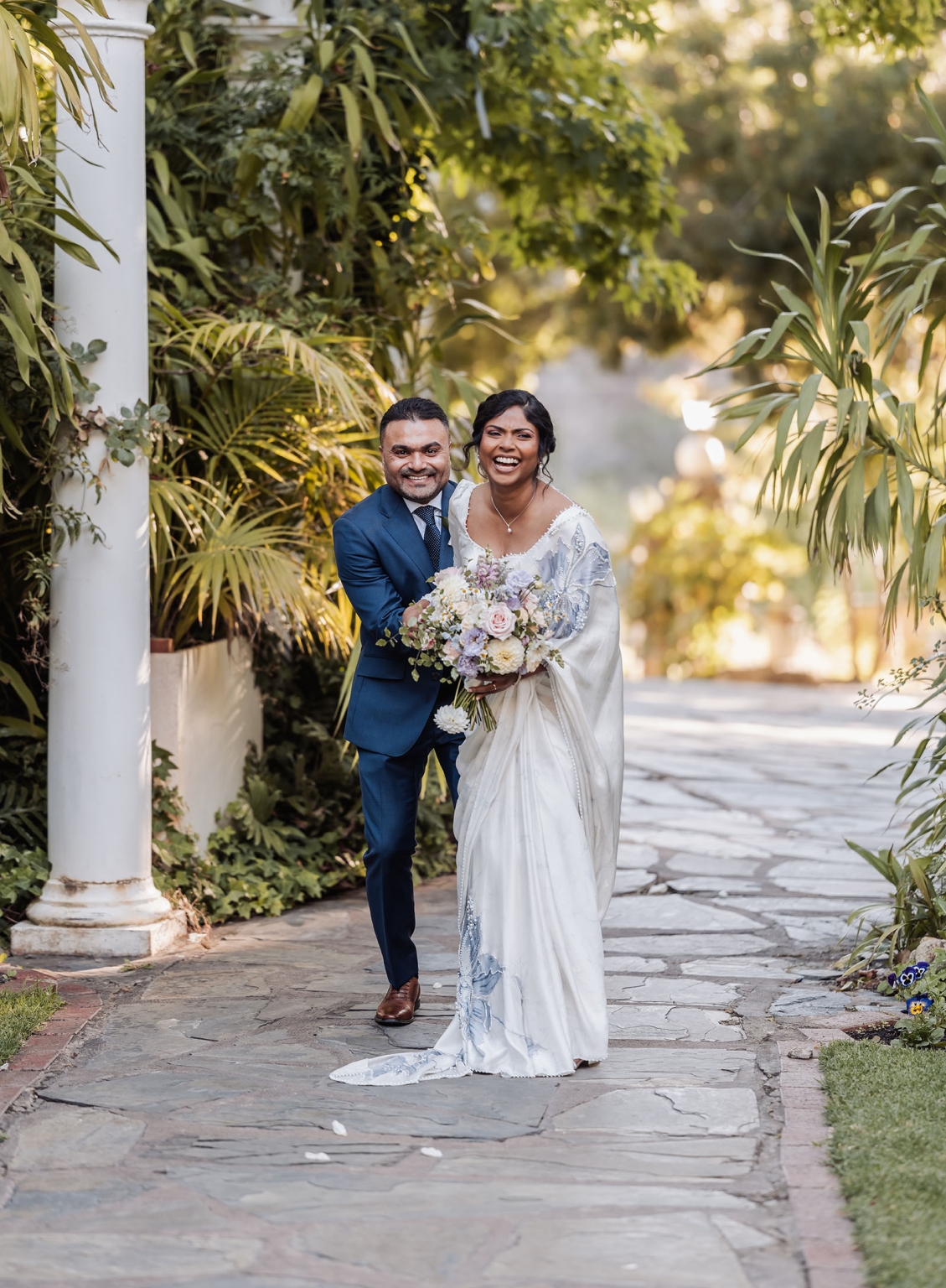 manor wedding in basket range - methmini & aravinda 150 Wedding couple in garden setting, bride in sari, groom in suit, joyful expressions.