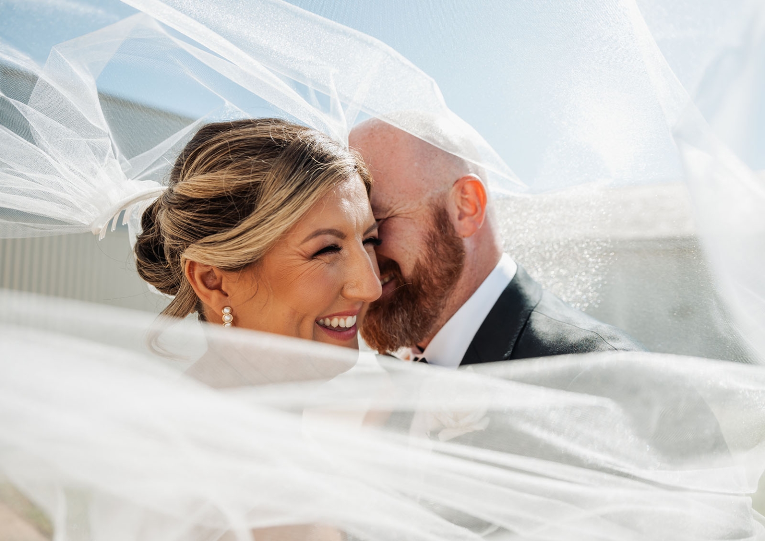 lloyd brothers wedding - dajana & tom 28 Bride and groom sharing a joyful moment under a delicate, flowing wedding veil.