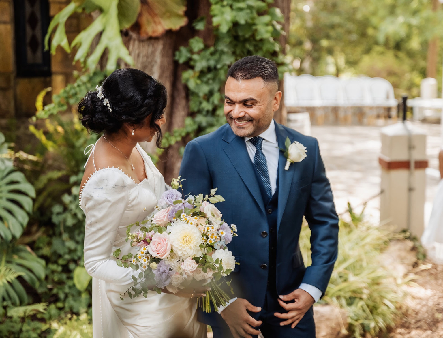 manor wedding in basket range - methmini & aravinda 126 Bride and groom in elegant attire celebrating outdoors with lush garden backdrop.