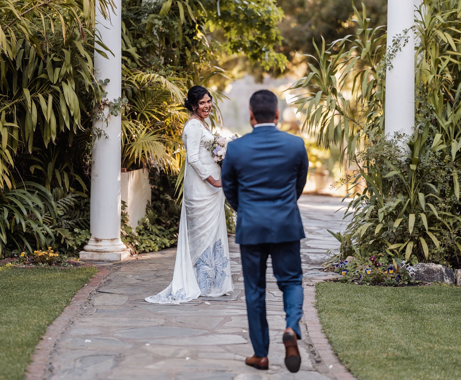 manor wedding in basket range - methmini & aravinda 149 Bride and groom in garden setting, joyful moment, elegant attire, romantic ambiance.