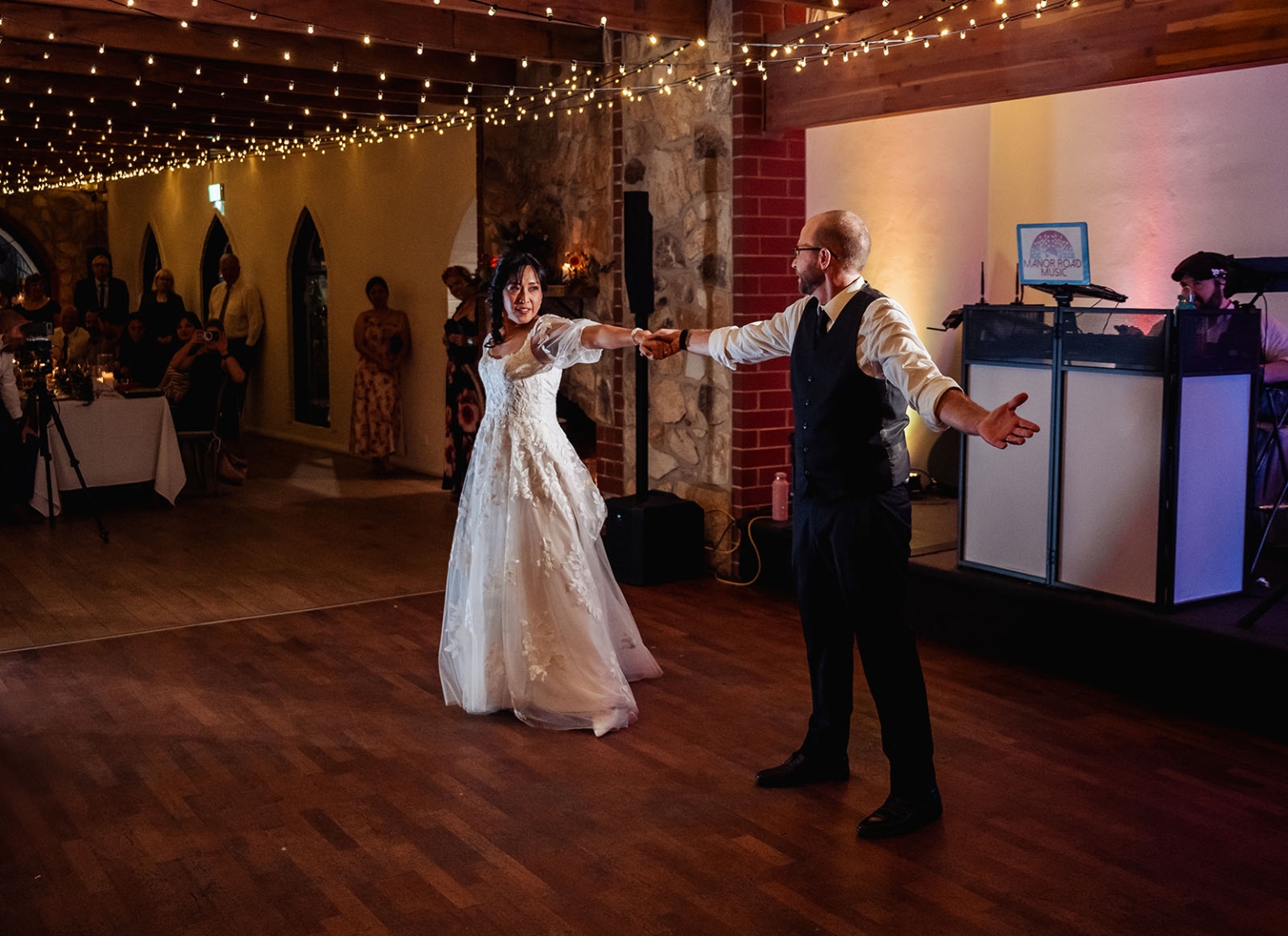 adelaide hills wedding at the manor - jo & dan 72 Bride and groom first dance at rustic wedding reception with string lights.