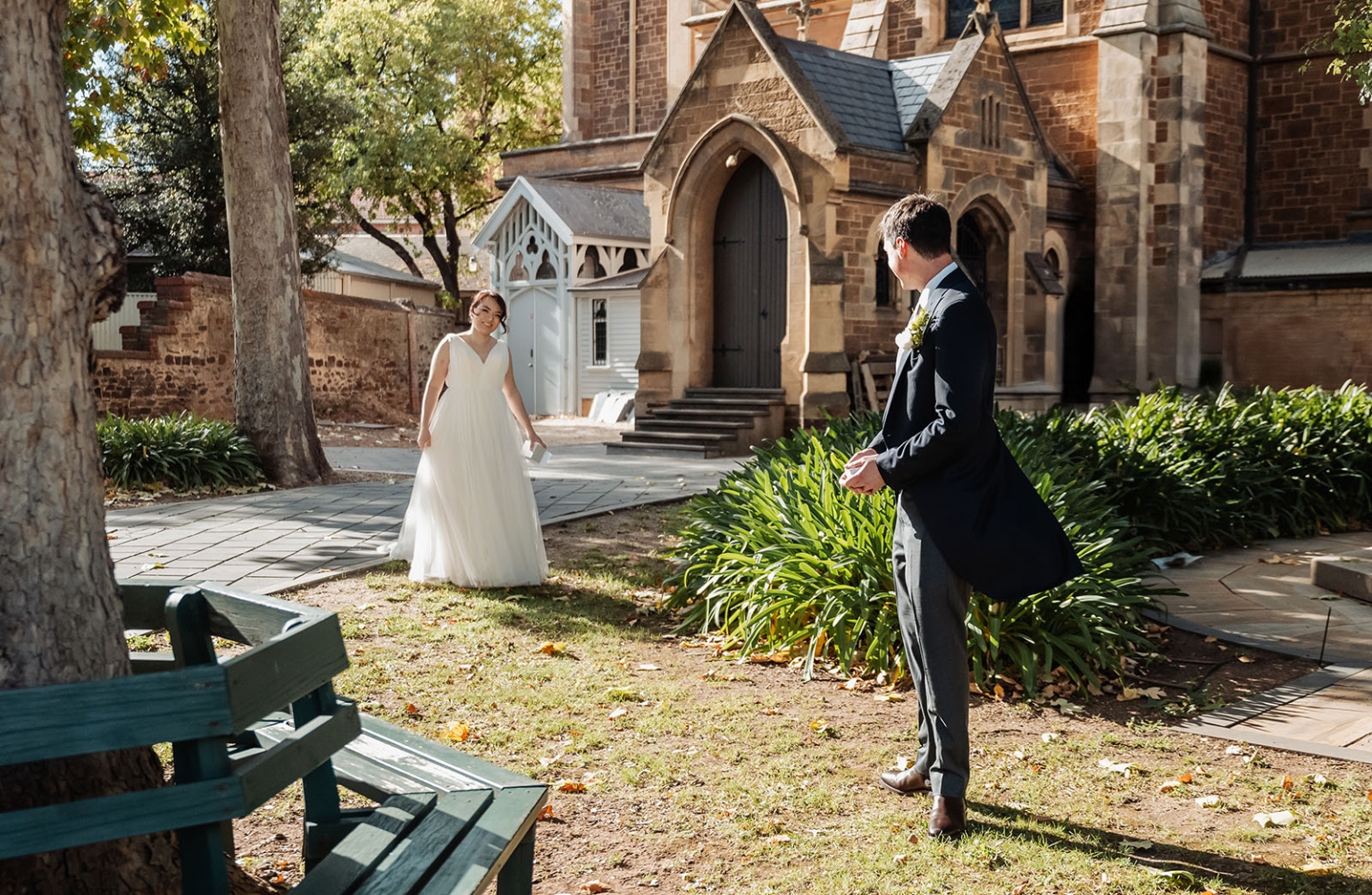 adelaide's st peter's cathedral wedding - irish & nick 6 Wedding bride and groom first look in sunlit church garden courtyard.