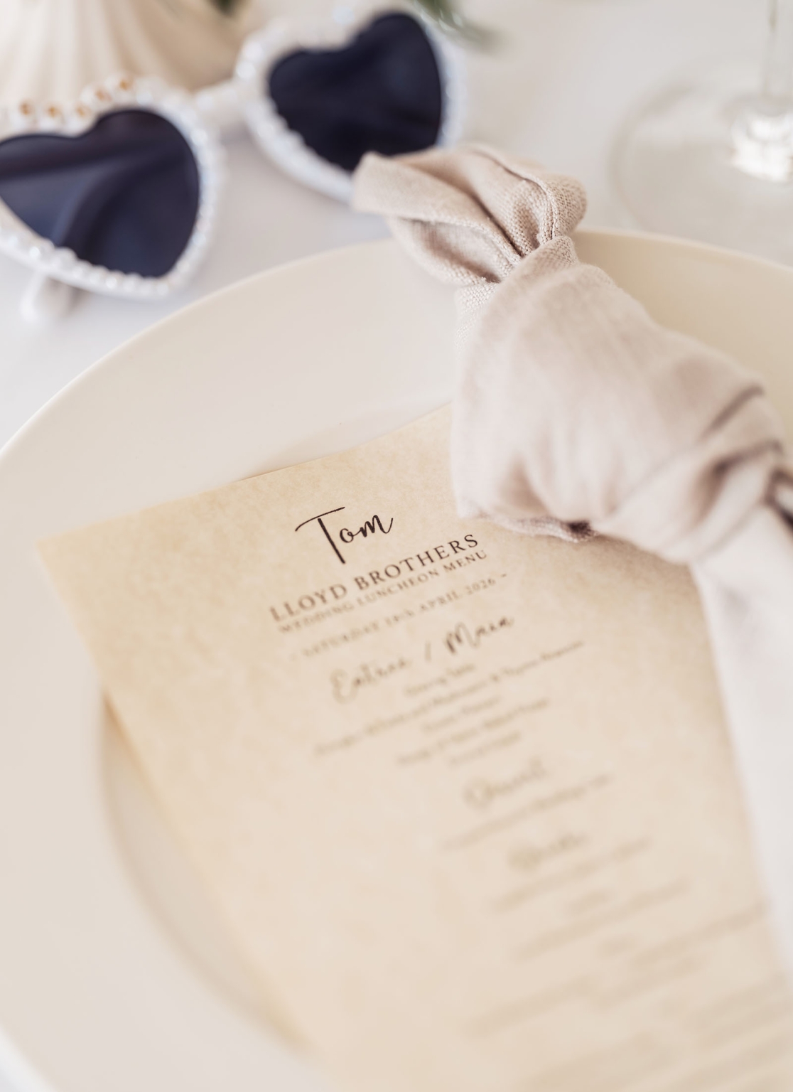 lloyd brothers wedding - dajana & tom 3 Elegant wedding luncheon table setting with menu, napkin, and heart-shaped sunglasses.