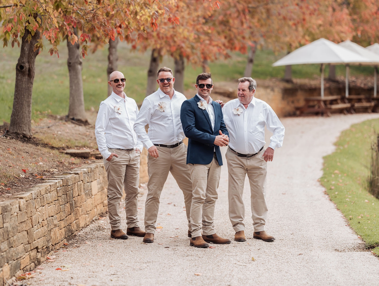 the lane vineyard wedding - caitlyn & craig 99 Autumn wedding party on gravel path with trees, featuring groom in navy blazer.