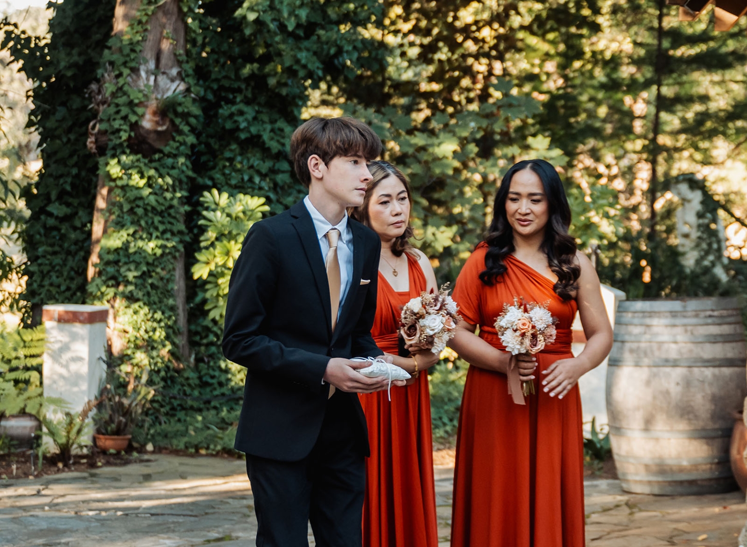adelaide hills wedding at the manor - jo & dan 27 Wedding party in garden ceremony with bridesmaids, ring bearer, and floral bouquets.