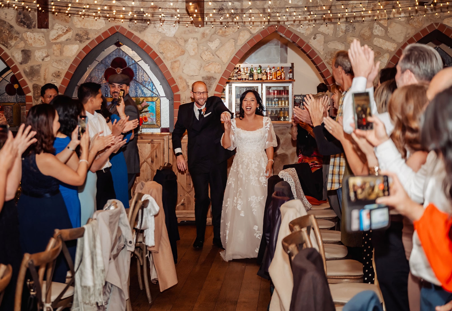 adelaide hills wedding at the manor - jo & dan 60 Joyful wedding reception entrance with bride and groom surrounded by cheering guests.
