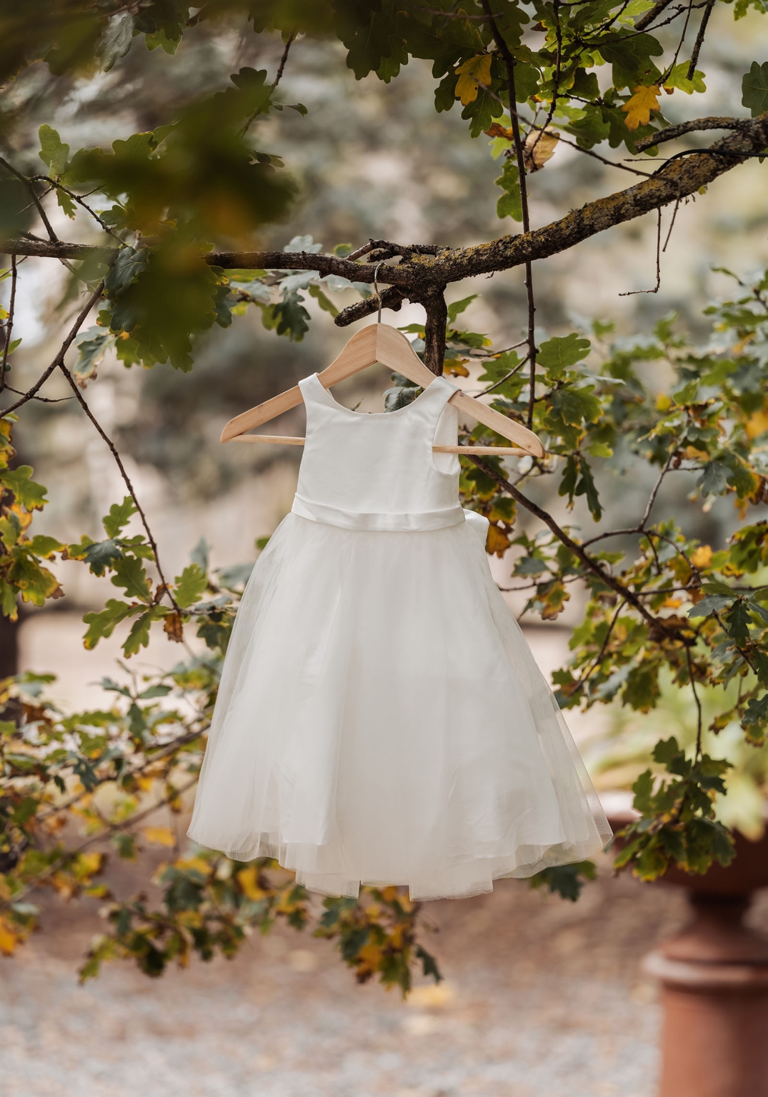the lane vineyard wedding - caitlyn & craig 78 Elegant white dress on tree branch in vibrant autumn setting.