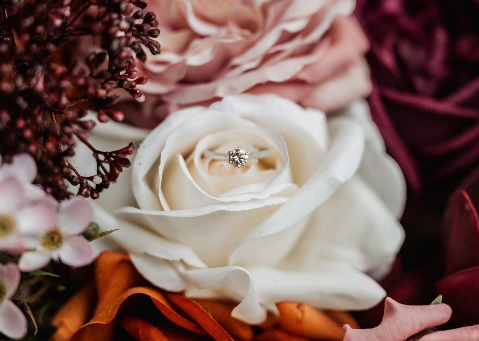engagement rings under $2,000: 7 designs that don't look cheap 5 Engagement ring in white rose with colorful floral arrangement.