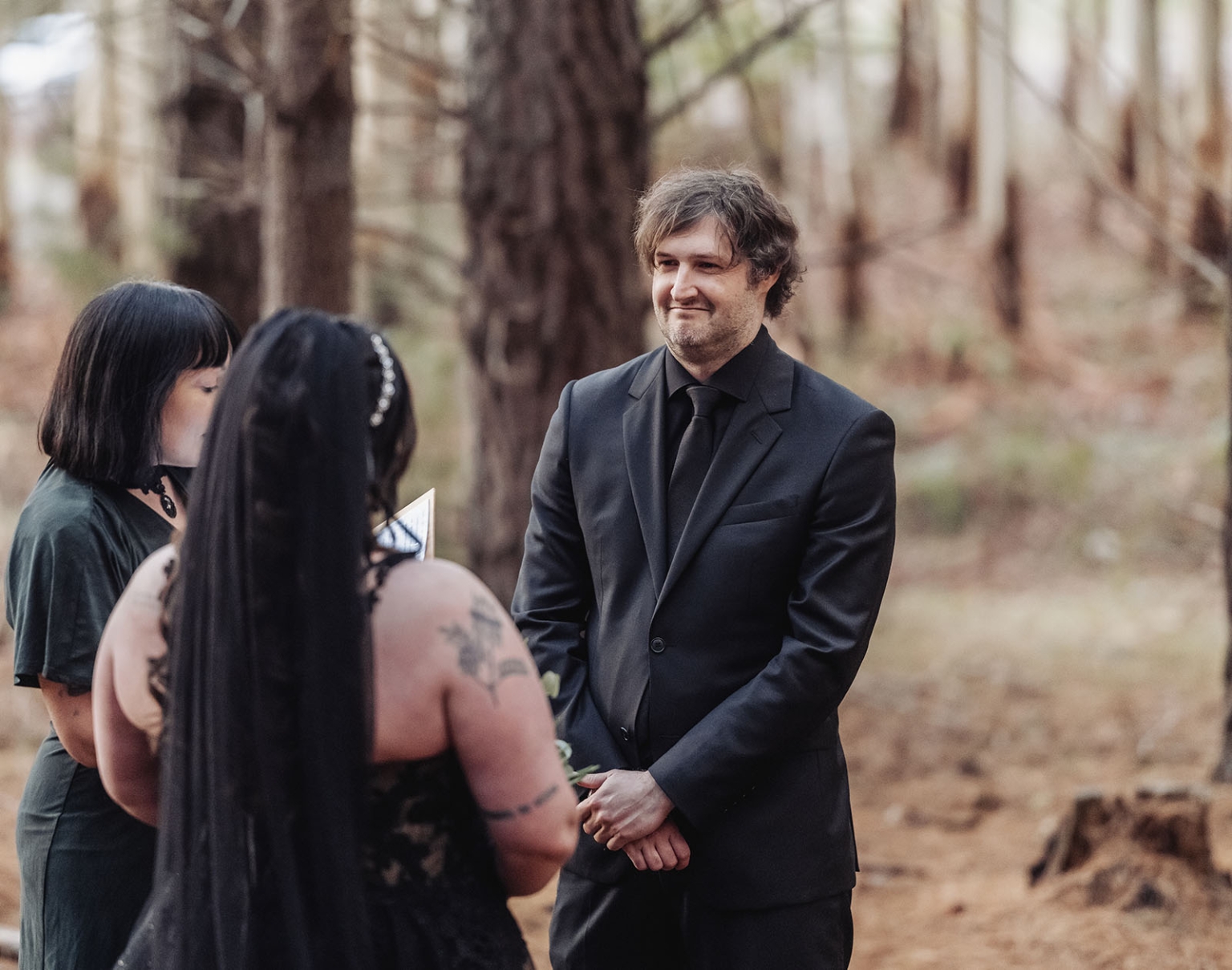 kuitpo forest metal themed wedding – erin & michael 4 Gothic woodland wedding ceremony with black-clad couple and officiant in a forest.