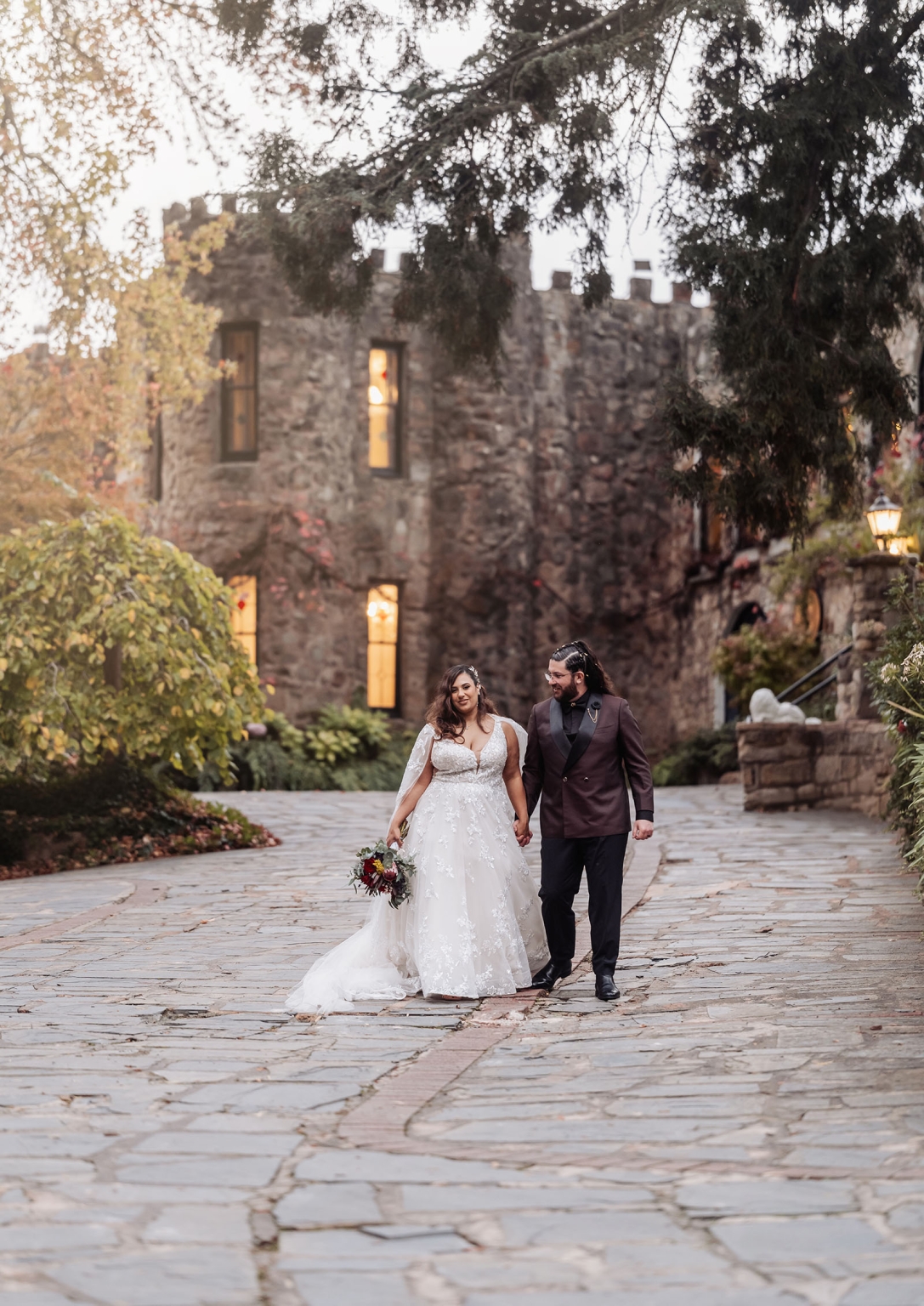 basket range wedding at the manor - leah & wes 59 Romantic castle wedding portrait of bride and groom walking through garden courtyard.