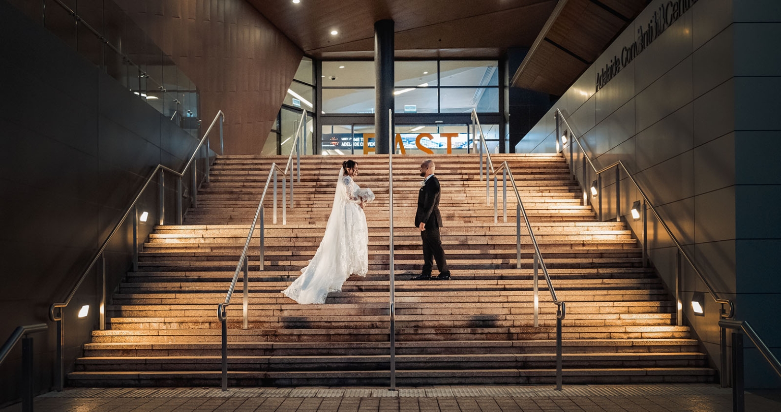 st george & st shenouda coptic church wedding - carmina & bill 77 Bride and groom on Adelaide Convention Centre wedding stairs at night.