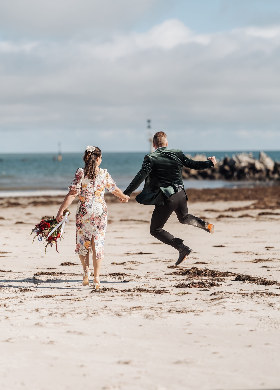 sa marriage office wedding – melissa & kyran 220 Joyful beach wedding couple holding hands by the ocean.