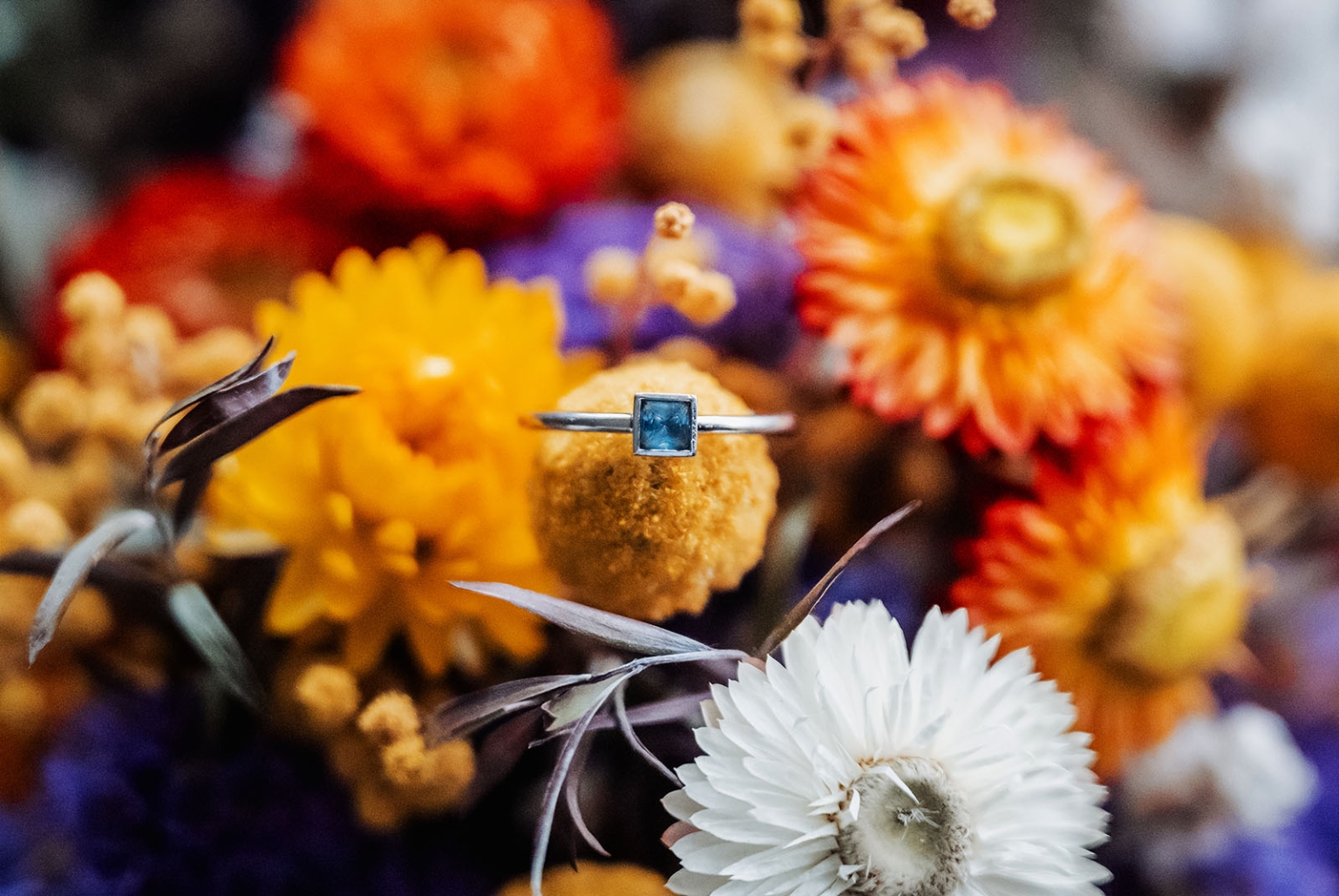 tiny house on the prairie wedding - lauren & bek 6 Blue gemstone silver ring on golden yellow flowers with rustic floral bouquet.