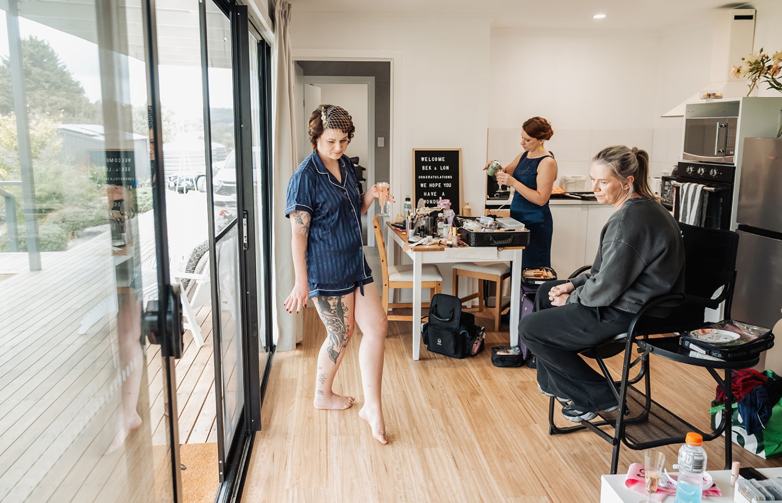 tiny house on the prairie wedding - lauren & bek 8 Bride getting ready in modern bridal suite with makeup artists and champagne.