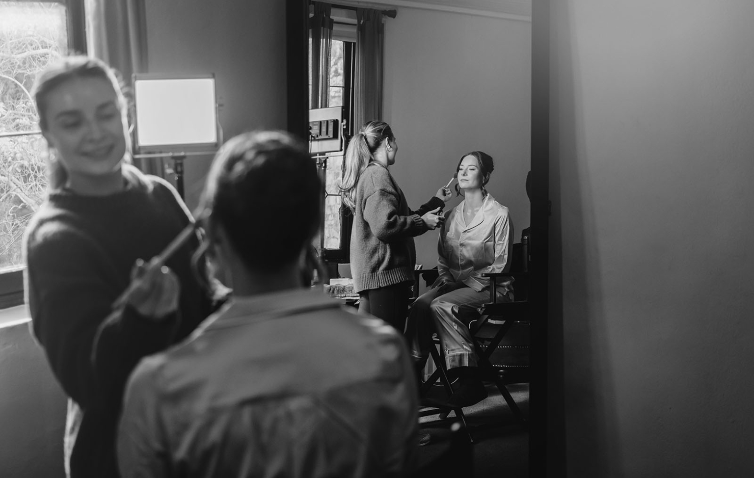 the manor wedding - crystal & mackenzie 12 Bride receives makeup during elegant black-and-white bridal preparation session.