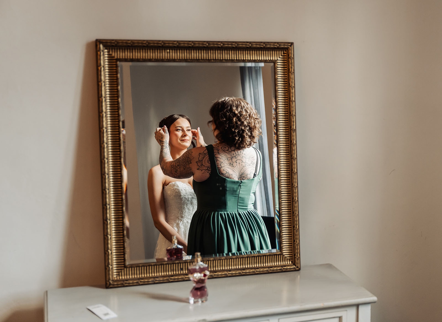 the manor wedding - crystal & mackenzie 18 Bride getting ready in mirror with bridesmaid adjusting makeup before wedding.
