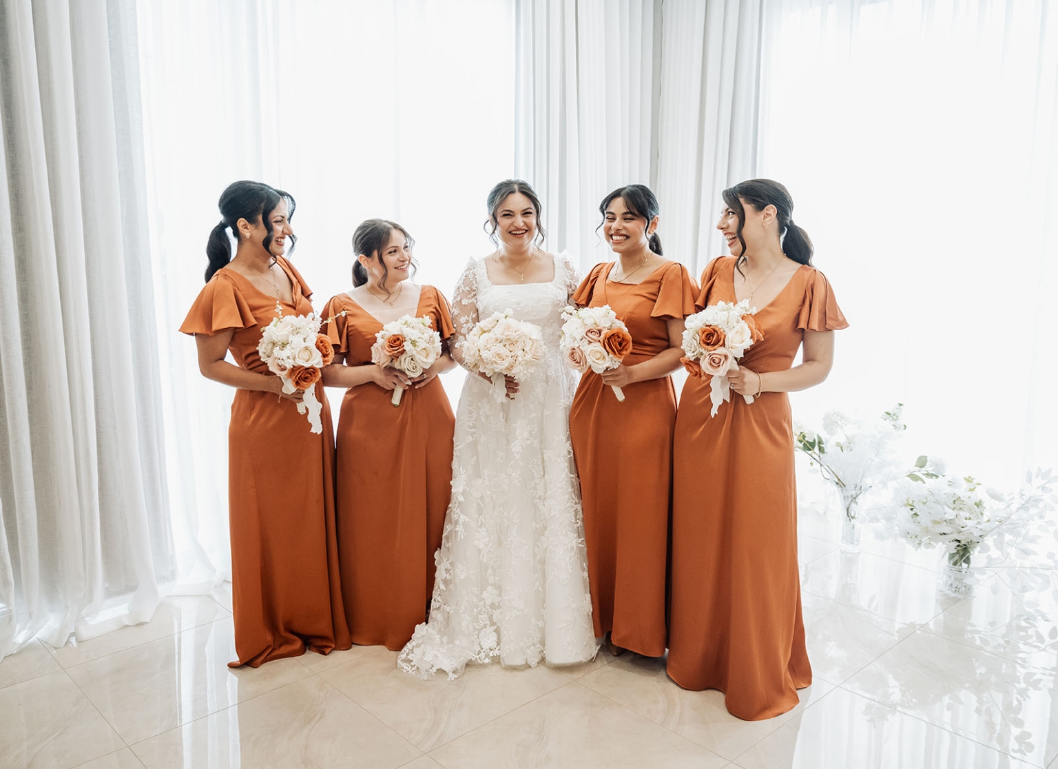 st george & st shenouda coptic church wedding - carmina & bill 28 Bride and rust orange bridesmaids with bouquets in elegant indoor wedding portrait.
