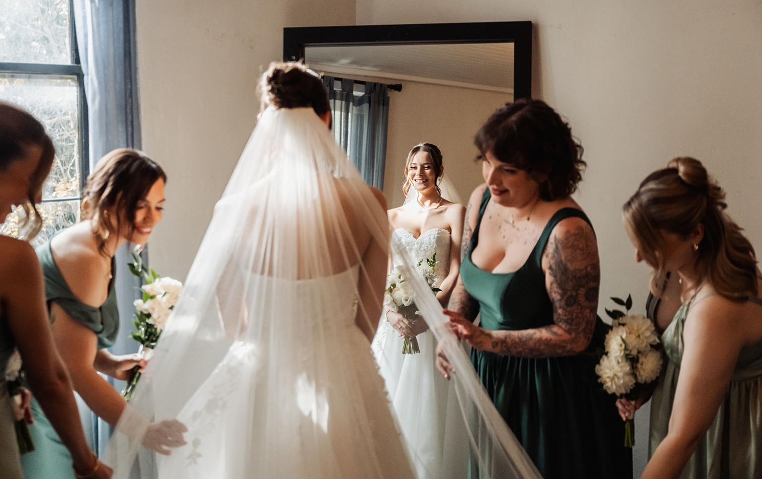 the manor wedding - crystal & mackenzie 24 Bride getting ready with bridesmaids adjusting veil before wedding ceremony.
