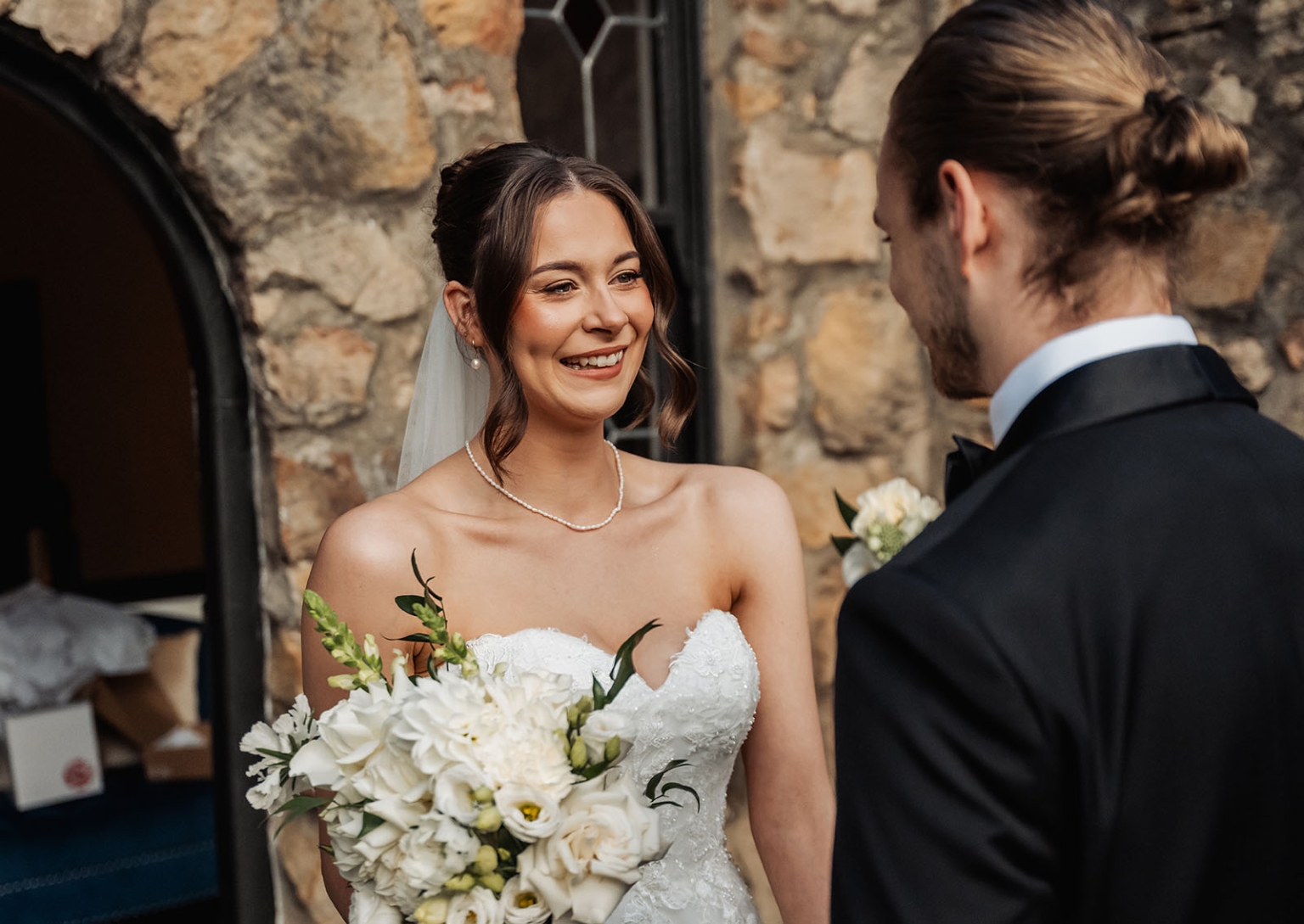 the manor wedding - crystal & mackenzie 40 Bride and groom wedding portrait with white bouquet outside rustic stone venue.