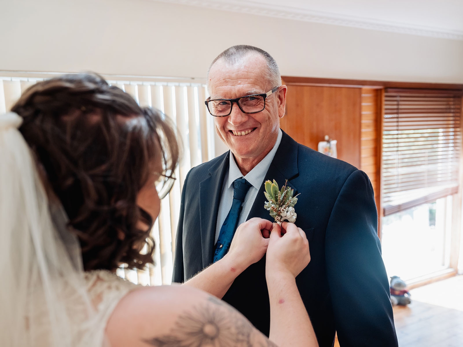 loxton's st peter's church wedding - madeline & brayden 28 Bride pins succulent boutonniere on father before wedding ceremony.