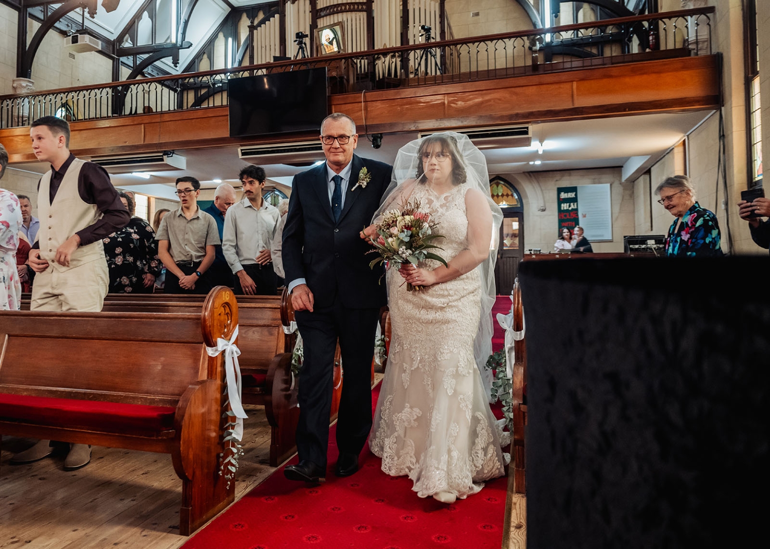 loxton's st peter's church wedding - madeline & brayden 31 Bride walking down church aisle with escort during traditional wedding ceremony.