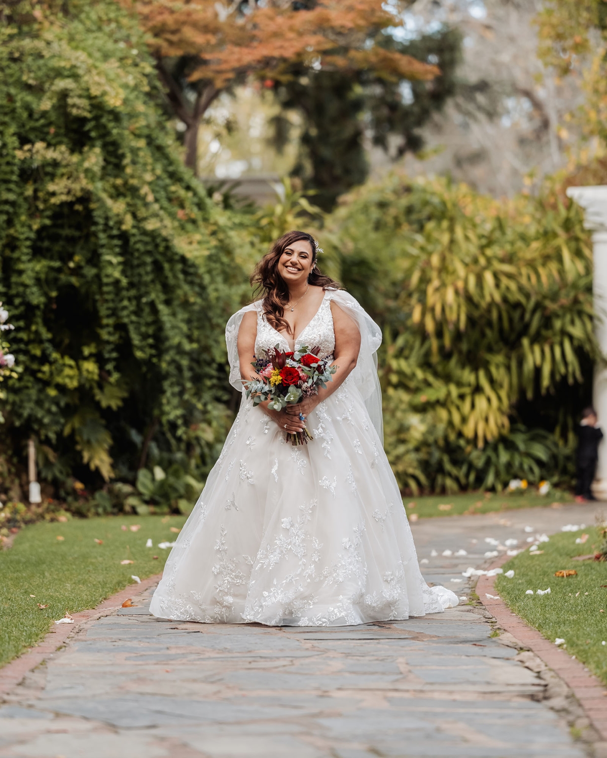 basket range wedding at the manor - leah & wes 43 Bride in white lace wedding gown holding bouquet on garden path.