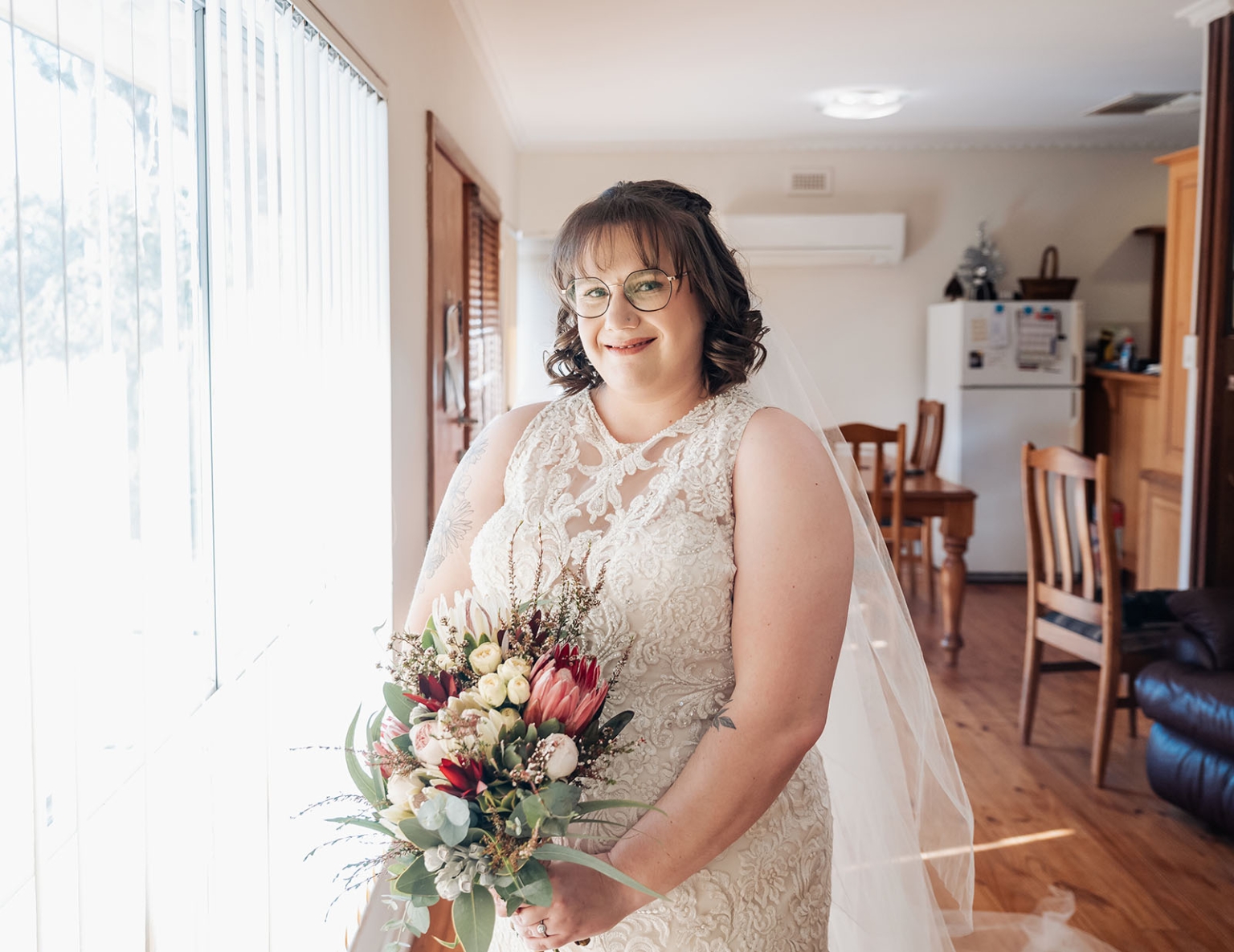 loxton's st peter's church wedding - madeline & brayden 26 Bride in lace wedding dress holding colorful bouquet indoors.