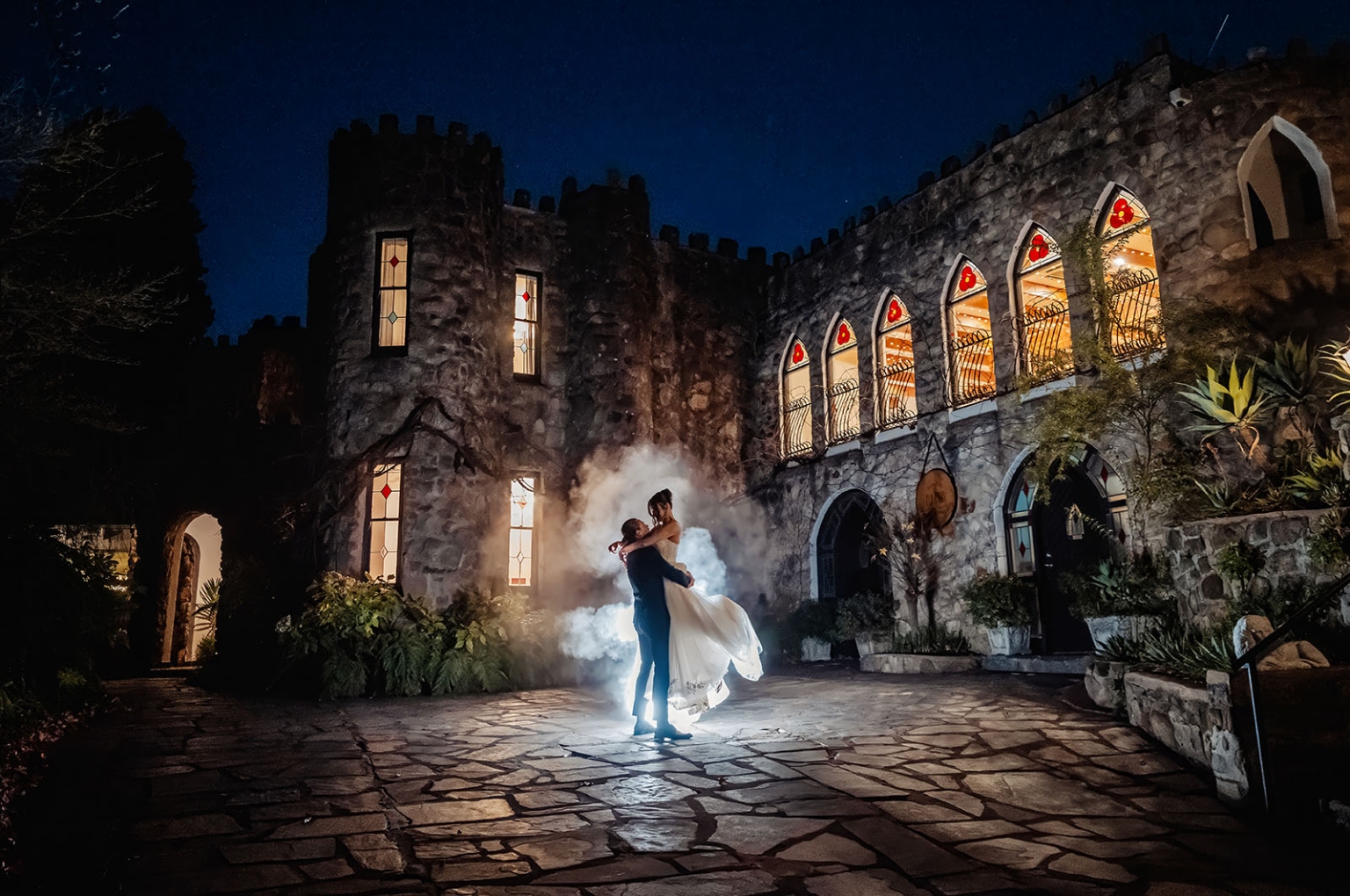 the manor wedding - crystal & mackenzie 97 Romantic castle wedding portrait at night with bride and groom in glowing courtyard.