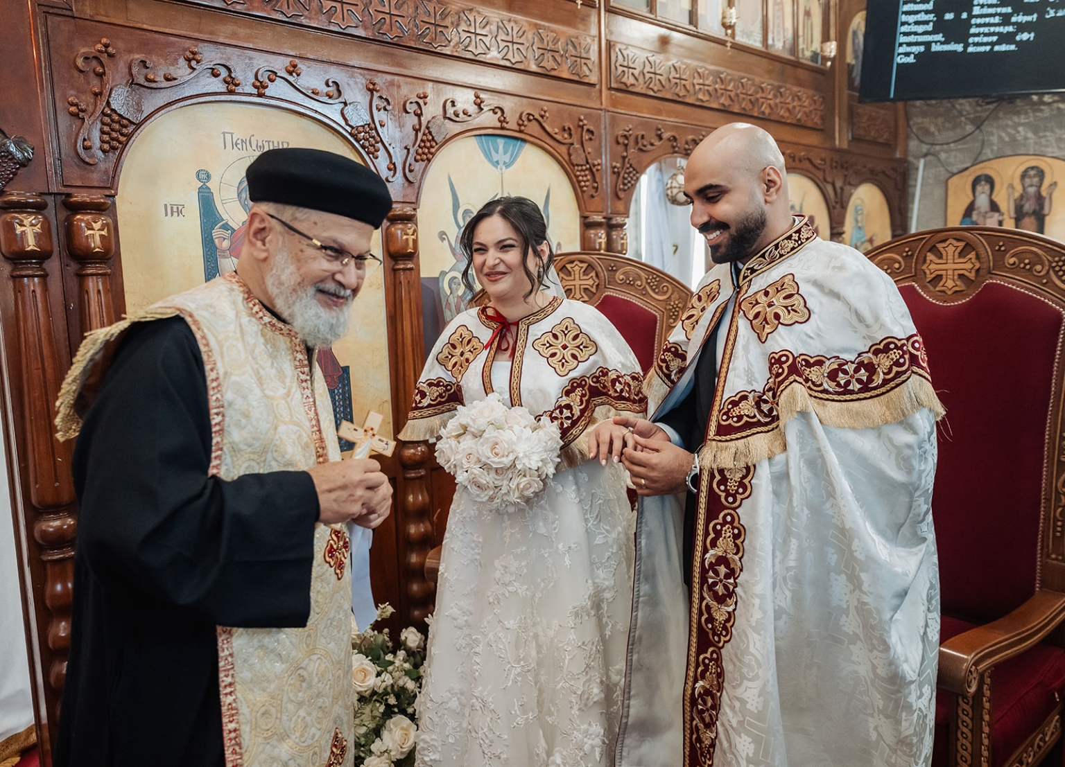 st george & st shenouda coptic church wedding - carmina & bill 45 Bride and groom with priest during traditional church wedding ceremony.