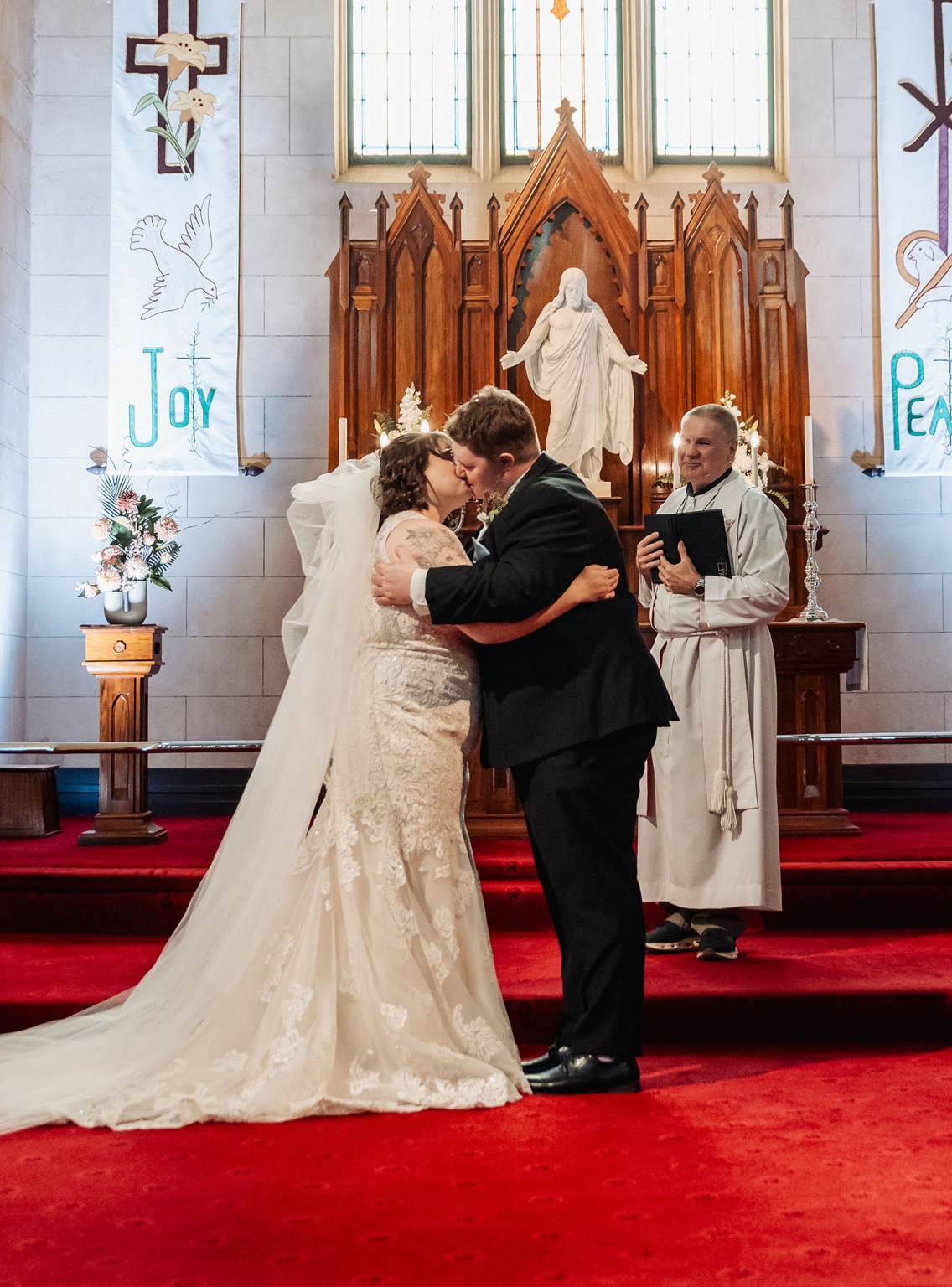 loxton's st peter's church wedding - madeline & brayden 38 Bride and groom kiss at church altar during traditional Christian wedding ceremony.