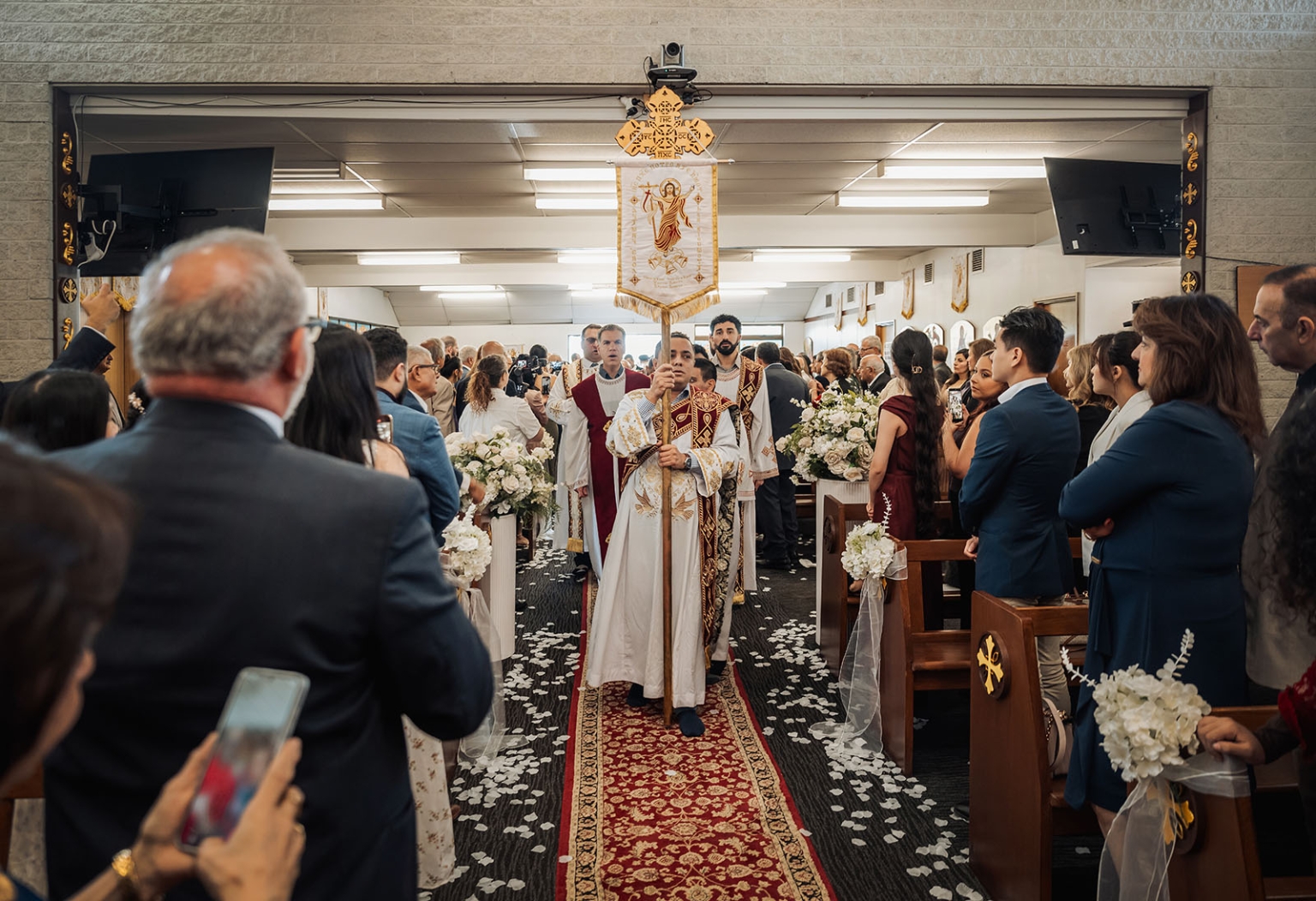 st george & st shenouda coptic church wedding - carmina & bill 36 Orthodox church wedding procession with clergy, floral aisle, and guests.