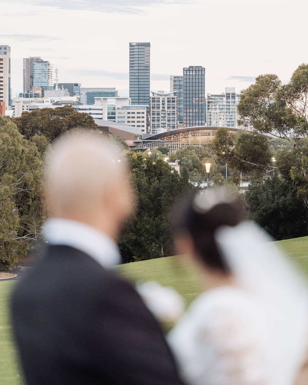 st george & st shenouda coptic church wedding - carmina & bill 74 Blurred couple overlooking city skyline from green park.