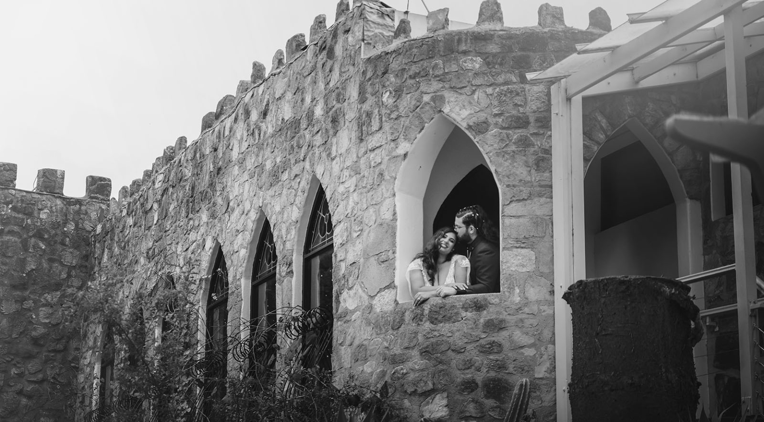 basket range wedding at the manor - leah & wes 39 Wedding couple posing in Gothic stone castle window.