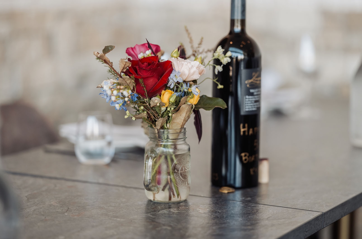sa marriage office wedding – melissa & kyran 212 Mason jar floral arrangement with red rose and wine bottle centerpiece.